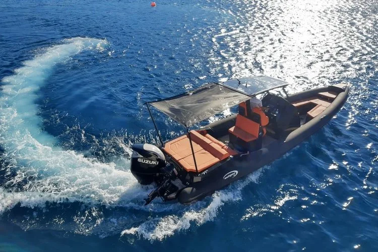 Rigid-inflatable motorboat anchored in a turquoise Corfu bay
